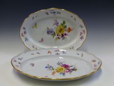 TWO MEISSEN OVAL PLATTERS FROM THE SAME SERVICE PAINTED WITH SCATTERED FLOWERS WITHIN WAVY GILT