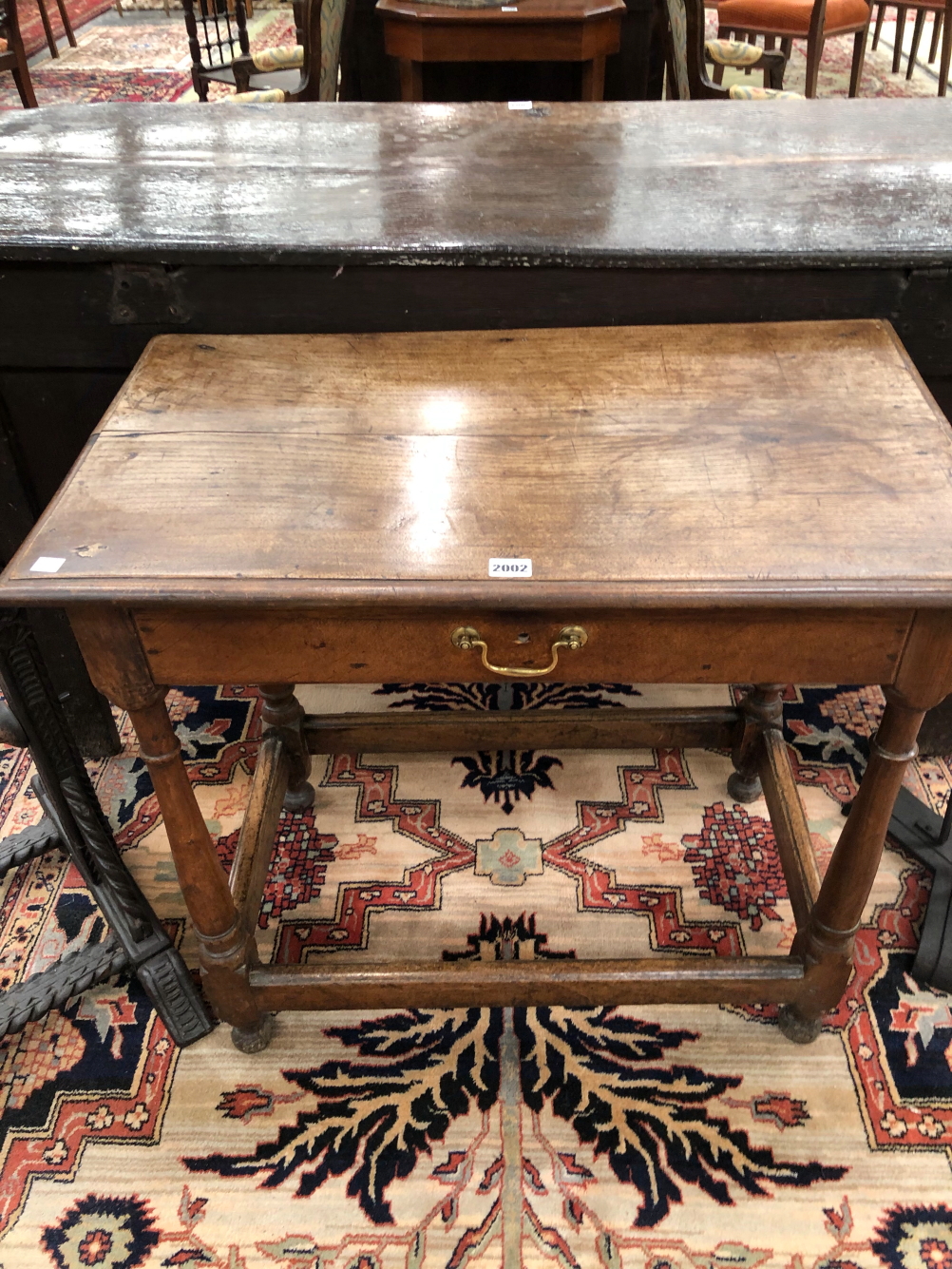 AN 18th C. OAK SIDE TABLE WITH SINGLE DRAWER ABOVE GUN BARREL LEGS JOINED BY STRETCHERS ABOVE THE