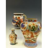 A CHINESE IMARI BALUSTER PINT MUG PAINTED WITH ISLANDS, A JAPANESE IMARI VASE AND ANOTHER LARGER.