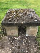 A SQUARE BOWED STONE BLOCK ON FOUR STONE SUPPORTS 76cms SQUARE HEIGHT 43cms, TOGETHER WITH ANOTHER