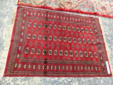 AN ORIENTAL RUG OF BOKHARA DESIGN 176 x 126 cms