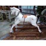 A VINTAGE WHITE PAINTED ROCKING HORSE WITH LEATHER SADDLE AND EASTERN COIN NECKLACE REINS- (