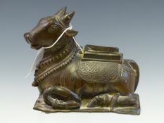 A BRONZE FIGURE OF NANDI, THE BULL VAHANA OF SHIVA RECLINING WITH TWO GARLANDS AROUND HIS NECK. W
