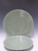 THREE CHINESE CELADON DISHES, EACH INCISED WITH FLOWER HEAD CENTRES ENCLOSED BY FLOWERING VINE