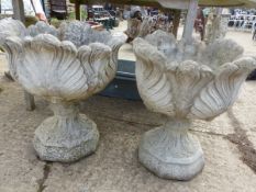 A PAIR OF COMPOSITE GARDEN URNS ON STANDS