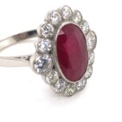 A RUBY AND DIAMOND OVAL CLUSTER RING. UNHALLMARKED, ASSESSED AS PLATINUM. FINGER SIZE N. WEIGHT 6.