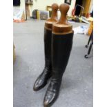 A PAIR OF VINTAGE BLACK LEATHER RIDING BOOTS WITH WOODEN TREES.