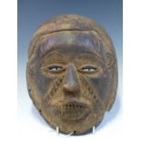 A 19th C. DAN BAOBAB WOODEN MASK, ITS BARED TEETH SIGNIFYING A RECENT DEATH. H 28cms.