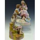 A ROBINSON AND LEADBEATER TINTED PARIAN GROUP OF A GIRL SEATED ON A ROCK DARNING WHILE A BOY