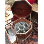 A GEORGE III MAHOGANY OCTAGONAL WINE COOLER WITH BRASS BOUND TWO HANDLED SIDES ABOVE FOUR LEGS. W 49