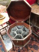 A GEORGE III MAHOGANY OCTAGONAL WINE COOLER WITH BRASS BOUND TWO HANDLED SIDES ABOVE FOUR LEGS. W 49