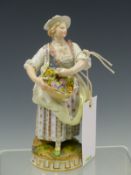 A MEISSEN FIGURE OF A LADY STANDING HOLDING A BASKET OF FLOWERS, HER HAT AND CLOTHES TRIMMED WITH