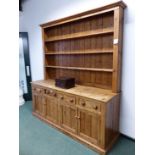A RUSTIC PINE FARM KITCHEN DRESSER, THREE SHELF UPPER SECTION ABOVE FOUR DRAWER BASE WITH PANELLED