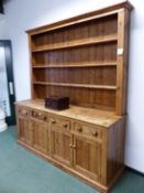 A RUSTIC PINE FARM KITCHEN DRESSER, THREE SHELF UPPER SECTION ABOVE FOUR DRAWER BASE WITH PANELLED