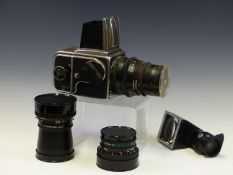 A CASED HASSELBLAD 500C/M CAMERA WITH ZEISS SONNAR 1:4, DISTAGON 1:4 AND PLANAR 1:2.8 LENSES,