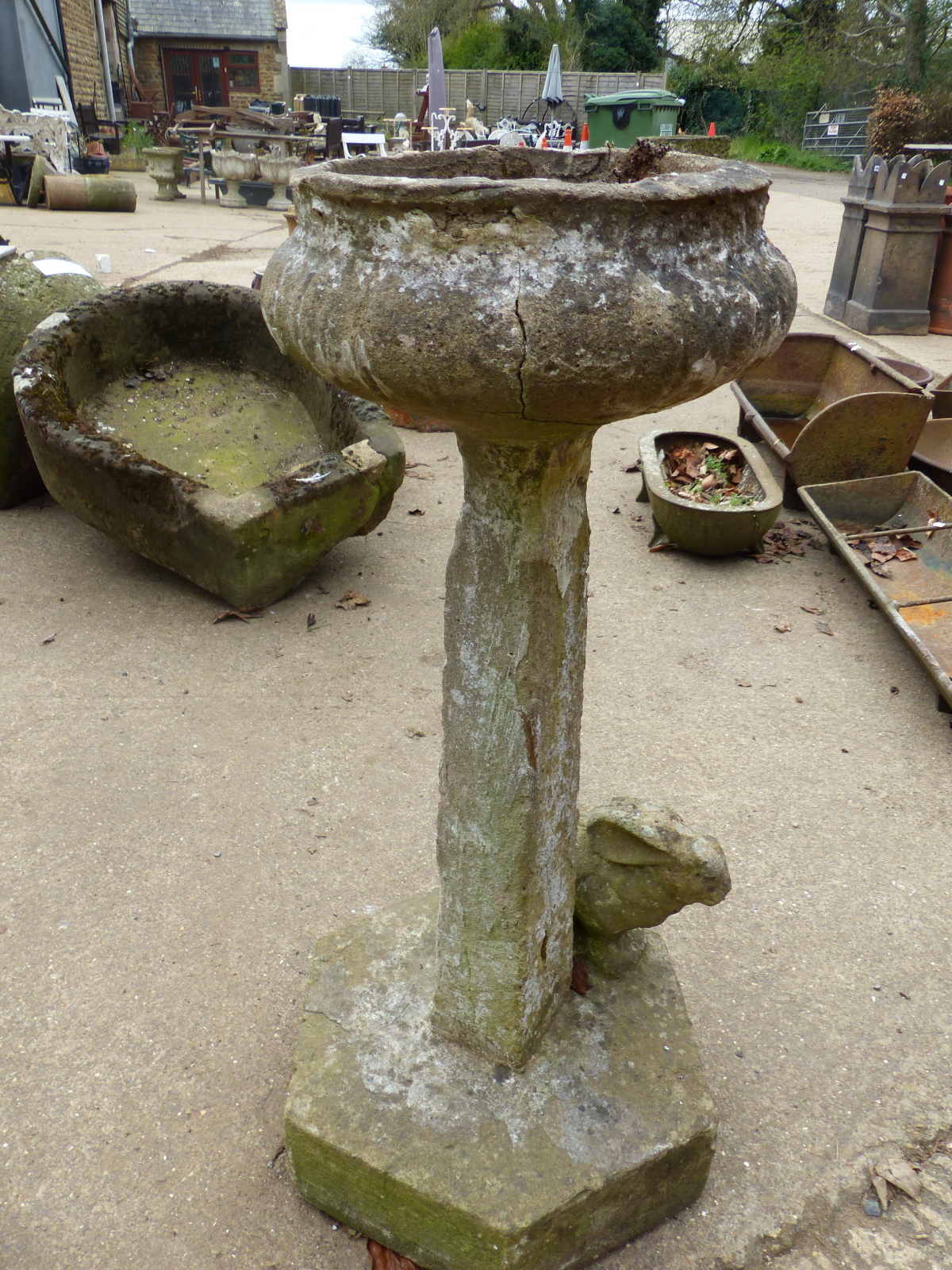 A CARVED COMPOSITE BIRD BATH WITH RABBIT FIGURE DECORATION TO BASE