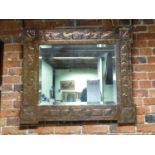 AN ARTS AND CRAFTS RECTANGULAR MIRROR IN A COPPER MOUNTED FRAME WORKED IN RELIEF WITH GRAPE VINES.