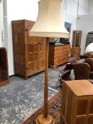 A ROBERT MOUSEMAN THOMPSON OAK STANDARD LAMP, THE OCTAGONAL COLUMN FLARING TO A STEPPED FOOT.