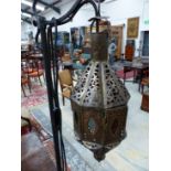 AN 19th CENTURY EASTERN STYLE BRASS LANTERN SUSPENDED AS A STANDARD LAMP FROM AND ADJUSTABLE ON AN