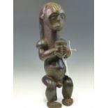 A LATE 19th C. KONDITE, GHANA, MAHOGANY FERTILITY FIGURE OF A MAN SEATED ON A STOOL HOLDING AN