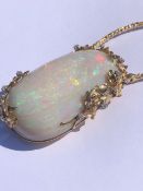 AN EXCEPTIONAL LARGE OPAL AND DIAMOND PENDANT, THE OVAL FORM OPAL MOUNTED IN A 14ct GOLD AND DIAMOND