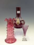 A CRANBERRY GLASS VASE SPIRALLY TRAILED IN CLEAR GLASS BELOW THE FRILLED RIM. H 23cms. AN AMETHYST