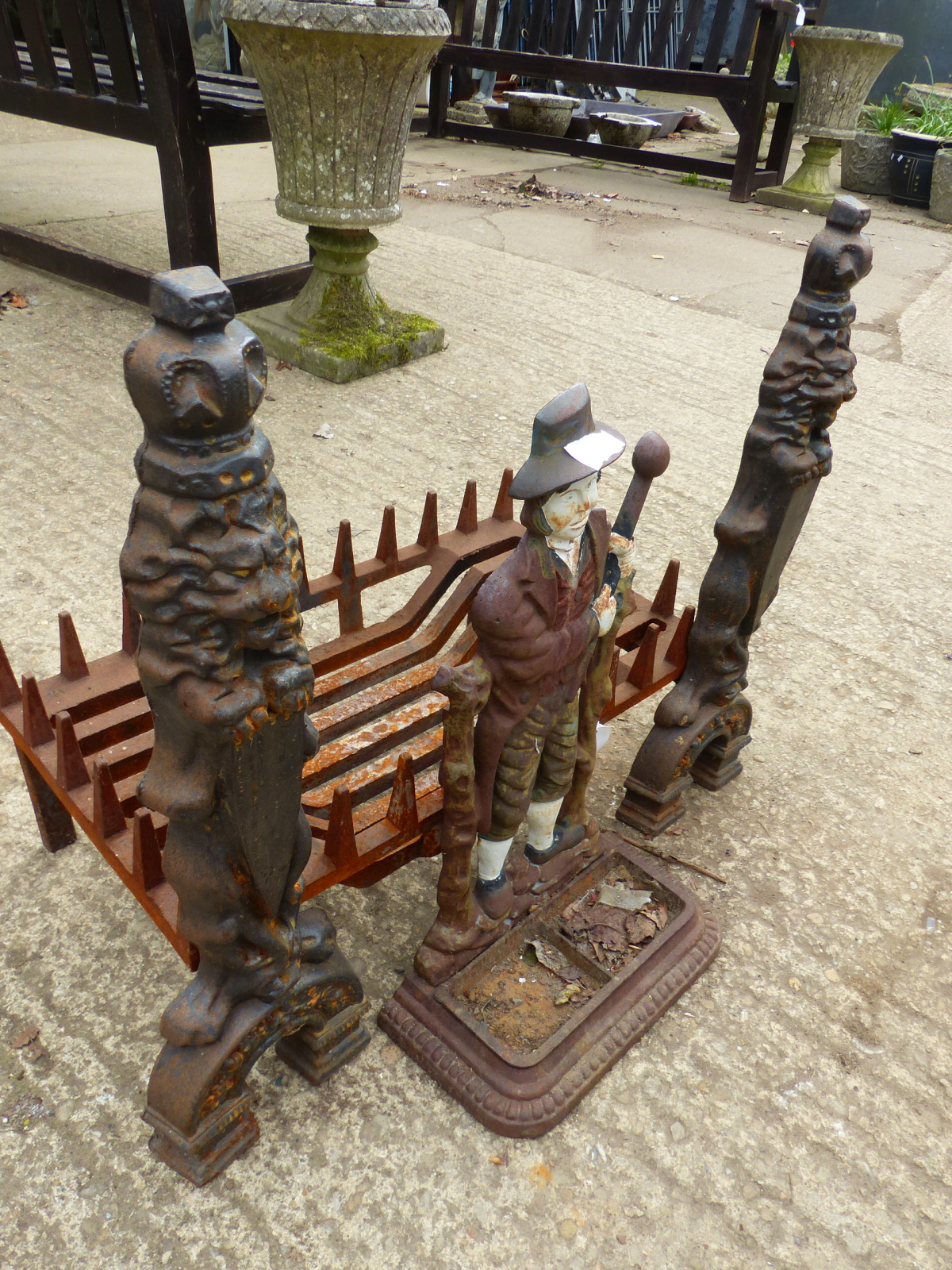 A CAST IRON FIRE GRATE WITH DOGS AND A STICK STAND
