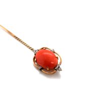 A VINTAGE CORAL AND DIAMOND STICK PIN. UNHALLMARKED ASSESSED AS 10ct GOLD. APPROX CORAL MEASUREMENTS