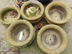 FIVE CARVED STONE URNS ON STANDS (5)