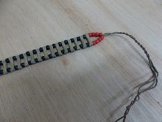 A 20th C. BORAN BELT MADE UP OF TWO STRINGS OF RED AND BLACK BEADS INTERSPERSED WITH THE BONES OF