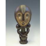 A LATE 19th C. ASANTE, MAHOGANY FERTILITY DOLL, HER FACE PAINTED IN OCHRE WITH WHITE DETAILS,