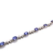 A TANZANITE AND DIAMOND LINE BRACELET. UNHALLMARKED AND STAMPED 850 PLAT, ASSESSED AS 850