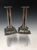 A PAIR OF SILVER CANDLESTICKS BY MUNSEY & CO, LONDON 1912, WITH BEADED BANDS ON THE SQUARE STEPPED