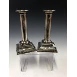 A PAIR OF SILVER CANDLESTICKS BY MUNSEY & CO, LONDON 1912, WITH BEADED BANDS ON THE SQUARE STEPPED