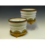 A PAIR OF GERMAN WHITE PORCELAIN PLANTERS, THE TRIPOD BASES AND BEADED RIMS IN ORMOLU. Dia. 19 x H