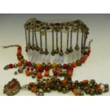 A VINTAGE TRIBAL NECKLACE SET WITH RED GLASS PANELS, AND STRUNG WITH BELLS, TOGETHER WITH A
