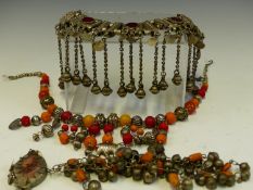 A VINTAGE TRIBAL NECKLACE SET WITH RED GLASS PANELS, AND STRUNG WITH BELLS, TOGETHER WITH A