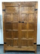 A ROBERT MOUSEMAN THOMPSON OAK WARDROBE WITH TWO PANELLED DOORS ENCLOSING HANGING SPACE AND TWO