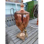 A TWO HANDLED COPPER HOT WATER URN AND COVER WITH A BRASS SPIGOT ABOVE THE SOCLE, STEPPED SQUARE