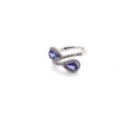 A TANZANITE AND DIAMOND INFINITY STYLE RING. UNHALLMARKED, ASSESSED AS 18ct WHITE GOLD. FINGER