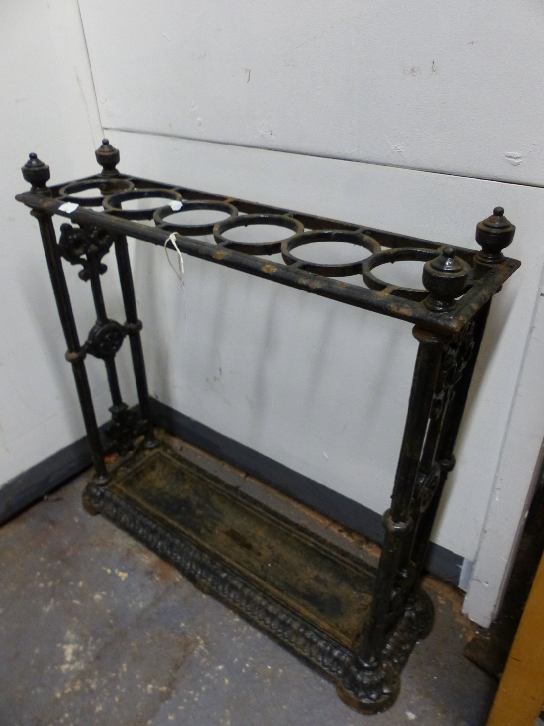 AN ANTIQUE COALBROOKDALE STYLE CAST IRON STICK STAND, THE TOP WITH SIX CIRCULAR HOLDERS, THE CENTRAL