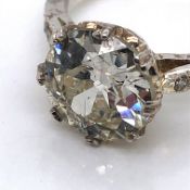 AN OLD CUT DIAMOND SINGLE STONE RING IN A DOUBLE EIGHT CLAW MOUNT UPON DIAMOND SET SHOULDERS.