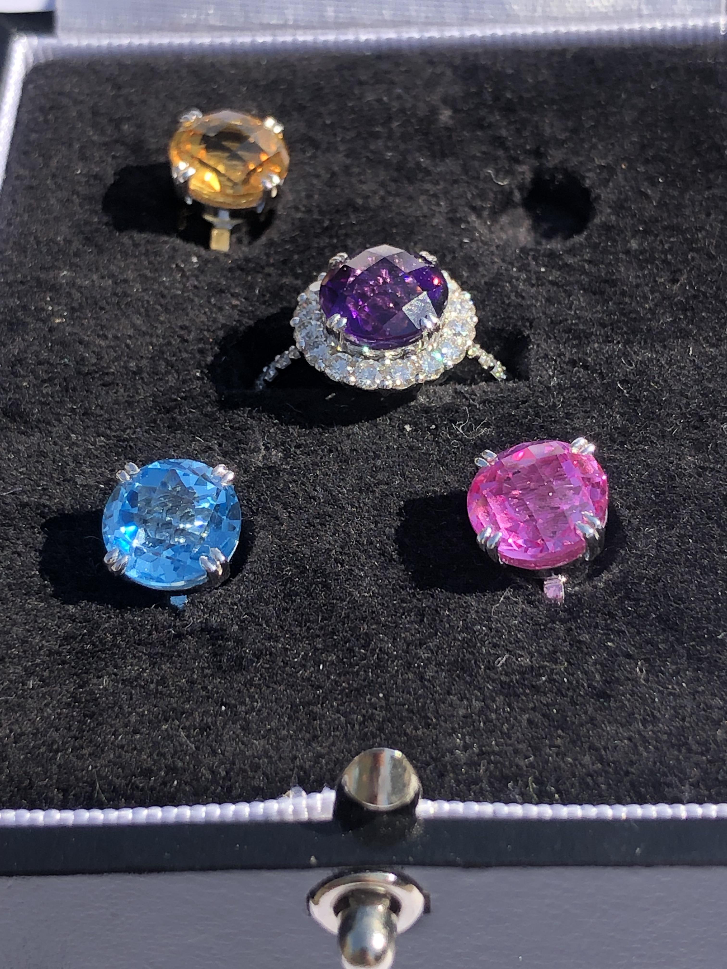AN INTERCHANGEABLE SWITCH GEM RING. THE MASTER RING IN A ROUND DIAMOND SET MOUNT WITH FOUR