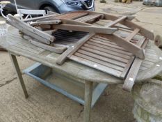 A TEAK GARDEN TABLE WITH THREE FOLDING CHAIRS.