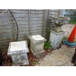 A PAIR OF COMPOSITE GARDEN PLINTHS TOGETHER WITH A SIMILAR URN ON STAND