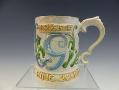 A COMPTON POTTERY CORONATION MUG FOR GEORGE V AND QUEEN MARY MOULDED IN RELIEF WITH THEIR INITIALS