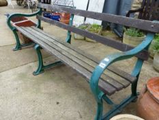 A LARGE ANTIQUE GARDEN BENCH WITH PAINTED CAST IRON SUPPORTS. H 74 x W 201 x D 73cms