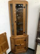 A ROBERT MOUSEMAN THOMPSON OAK CORNER CUPBOARD, THE UPPER HALF GLAZED, THE LOWER WITH FOUR
