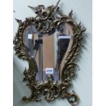 A BRASS FRAMED BEVELLED GLASS MIRROR, CAST WITH FOLIAGE AND ROCAILLE BELOW THE GRIFFIN CRESTING. H