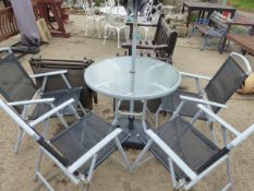 A MODERN GLASS TOP PATIO TABLE WITH A PARASOL AND FOUR MATCHING CHAIRS AND A PAIR OF SIMILAR SUN